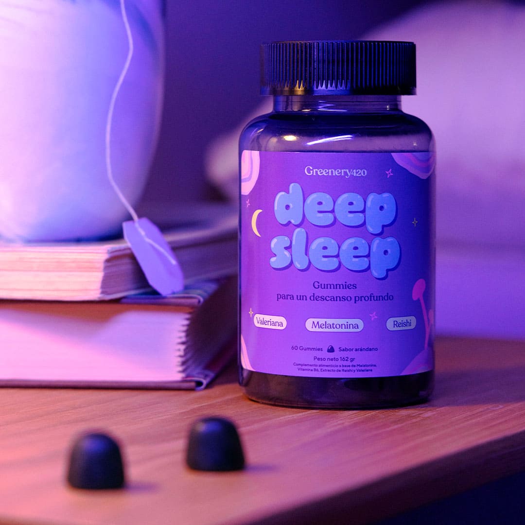 Gummies Deep Sleep Greenery Wellness junto a lámpara y libro en dormitorio