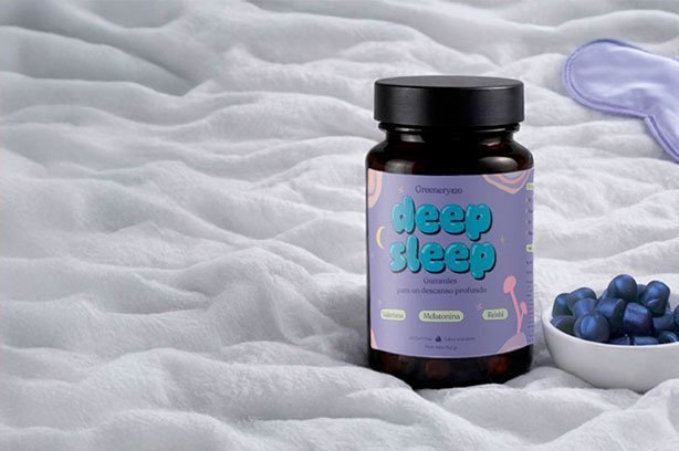 Gummies Deep Sleep Greenery Wellness sobre cama con antifaz y cuenco de gominolas azules